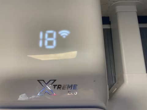Air conditioner LED display showing 18 degrees and a Wi-Fi connection symbol