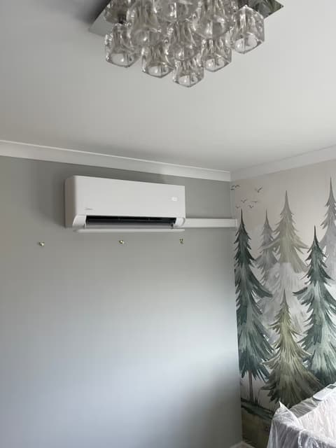 Air conditioning unit installed in a child’s bedroom with a woodland wall mural