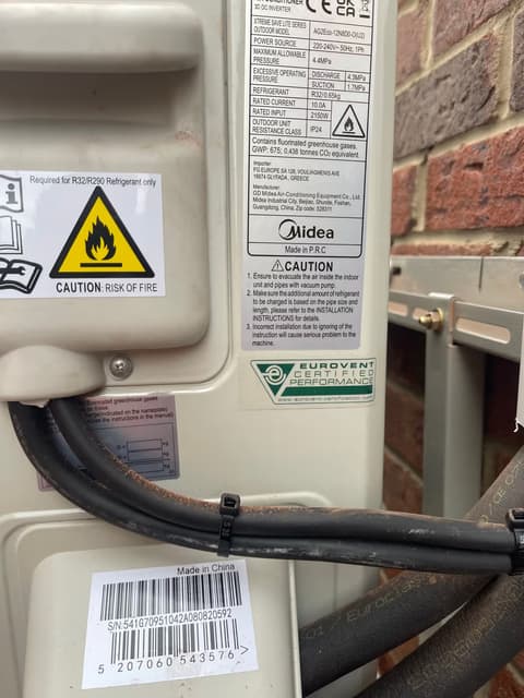 Close-up of air conditioning service valves and insulated refrigerant pipe connections